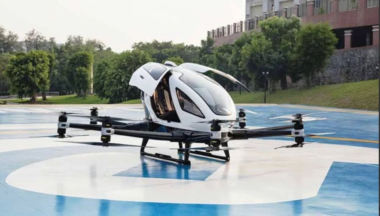 Futuristic flying car with doors open on helipad.
