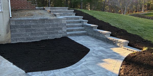 Newly constructed stone stairs and walkway with fresh soil beds around.