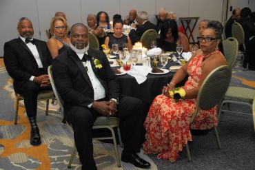 Group of people dressed formally at a banquet table.