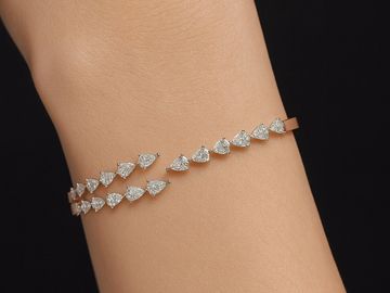 Elegant bracelet with heart-shaped diamonds on wrist.