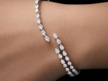 Elegant diamond bracelet with pear-shaped stones on wrist.