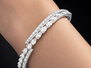 Elegant diamond bracelet with pear-shaped and round stones on wrist.