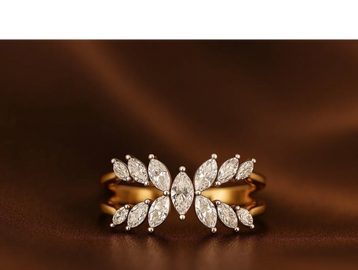 Elegant gold ring adorned with marquise-cut diamonds on a brown fabric background.