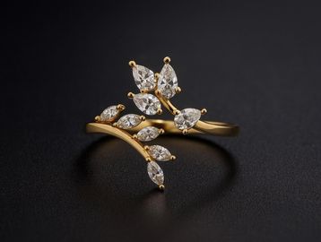 Elegant gold ring with leaf-shaped diamonds on a black background.