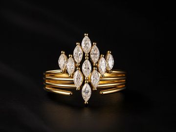 Elegant gold ring with marquise-cut diamonds arranged in a cross pattern.