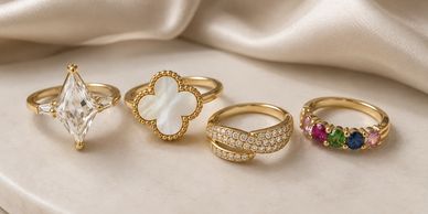 Four elegant gold rings with unique designs and gemstones.