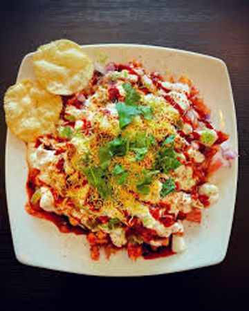 Plate of Indian chaat with crispy papad on the side.