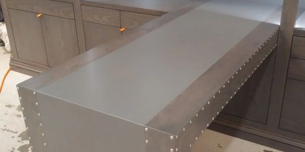 A combination of stained Ash wood with a satin paint solid color desk stripe, accented with Satin ni