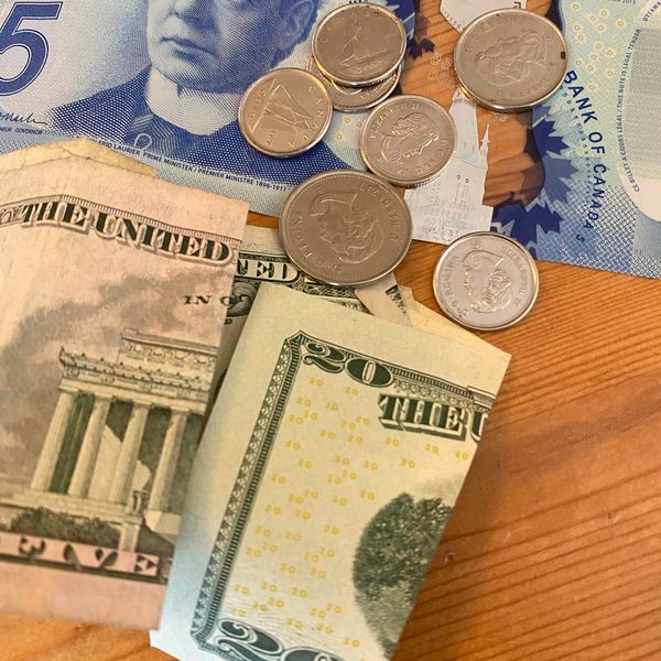 A collection of paper and coin money from Canada and the United States.