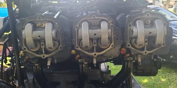 Close-up of a three-cylinder engine with visible camshafts and valves.