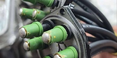 Close-up of green-tipped electrical connectors on a black cable.