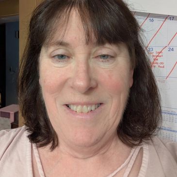 Smiling woman with dark hair and pale skin.