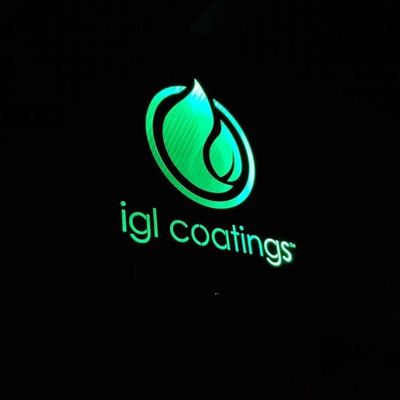 Glowing green logo of IGL Coatings on a black background.