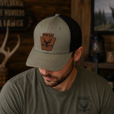 Man wearing a green cap and matching t-shirt with deer logo.