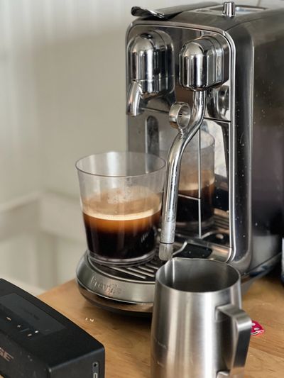 Brown sugar and espresso being brewed in a glass on an espresso machine.