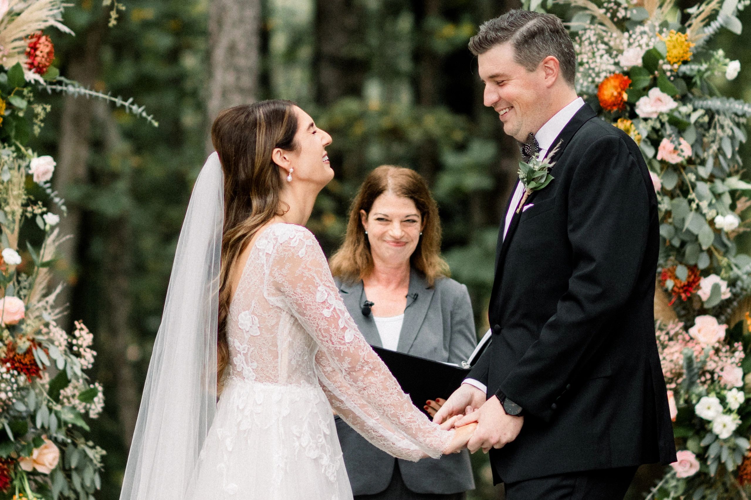 Bride and groom holding hands during a personalized outdoor wedding ceremony in Raleigh, NC.