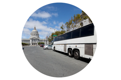 A large charter bus parked by the roadside, featuring sleek windows and a modern design. 