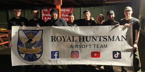The Royal Huntsman team members holding up their team banner.