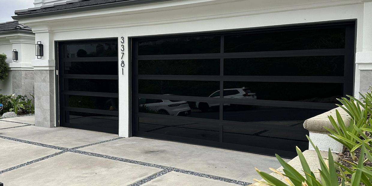Modern house with sleek black reflective garage doors and house number 33781.