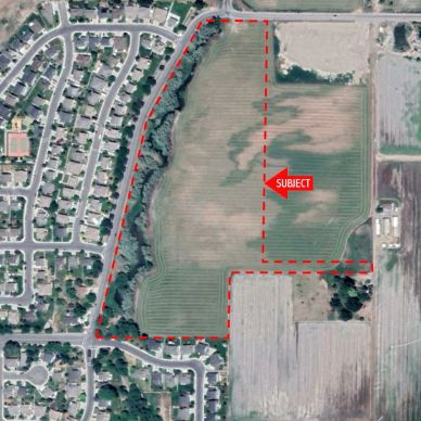 Aerial view of a field marked as subject near residential area.