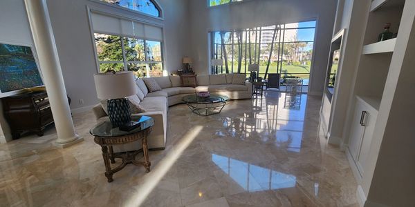 Spacious living room with large windows and a cream sectional sofa.