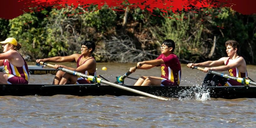 Team rowing in unison on a river during a race.
