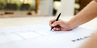 Person writing on a paper chart with a pen