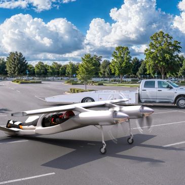 A small, futuristic aircraft in a parking lot.