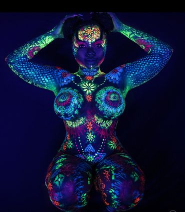 Glow body painted woman painted with black light uv party paint.  Painted  art was done in miami for