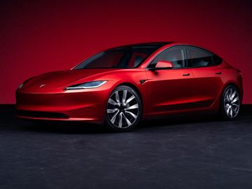 A sleek red Tesla Model S sedan against a red background.
