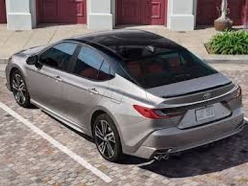 A sleek gray sedan parked in a driveway with a cobblestone surface.