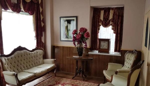 Vintage living room with classic furniture and floral arrangement.