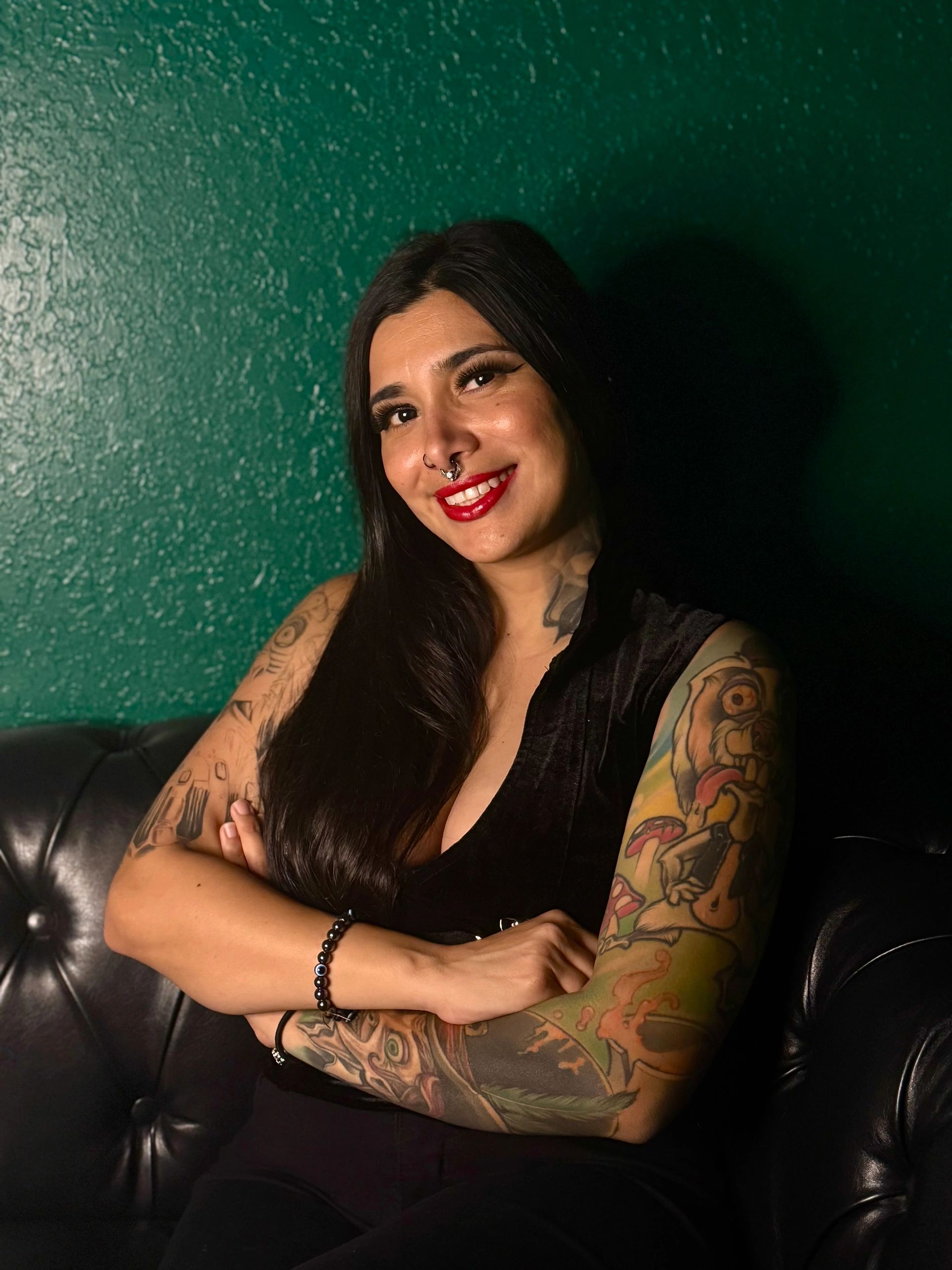 Smiling tattooed woman with septum piercing.