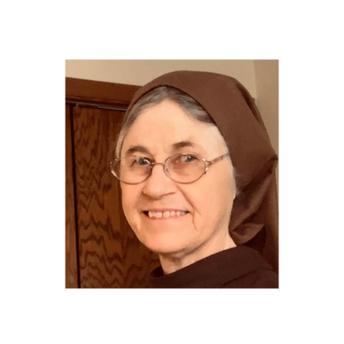 Smiling elderly woman wearing glasses and a brown headscarf.