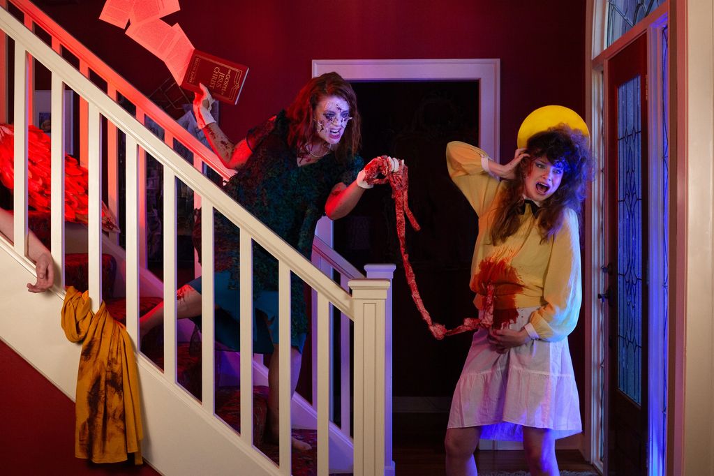 Two women involved in a horror scene with fake blood and intestines.