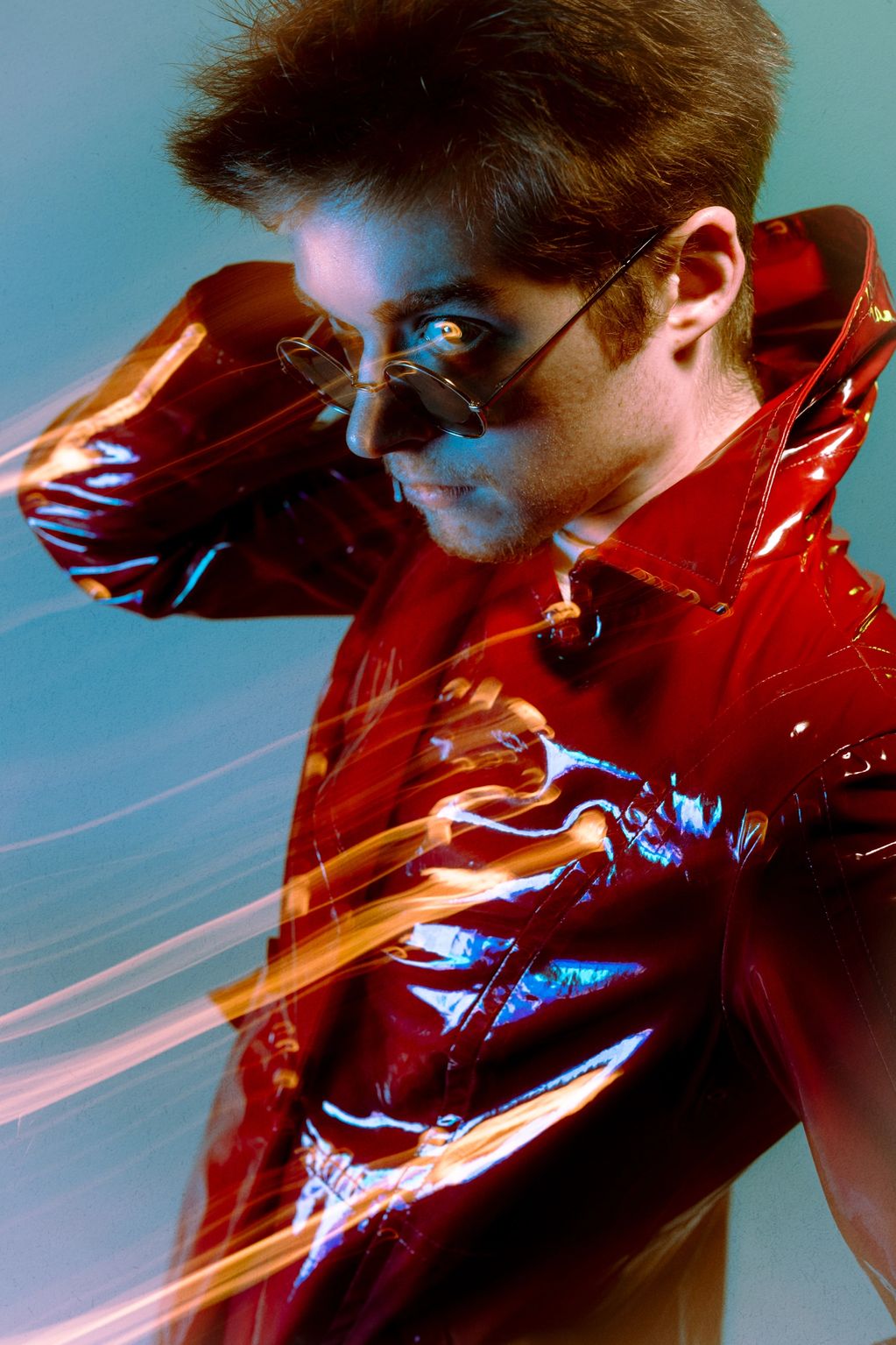 Man in red shiny jacket with glasses and light streak effects.