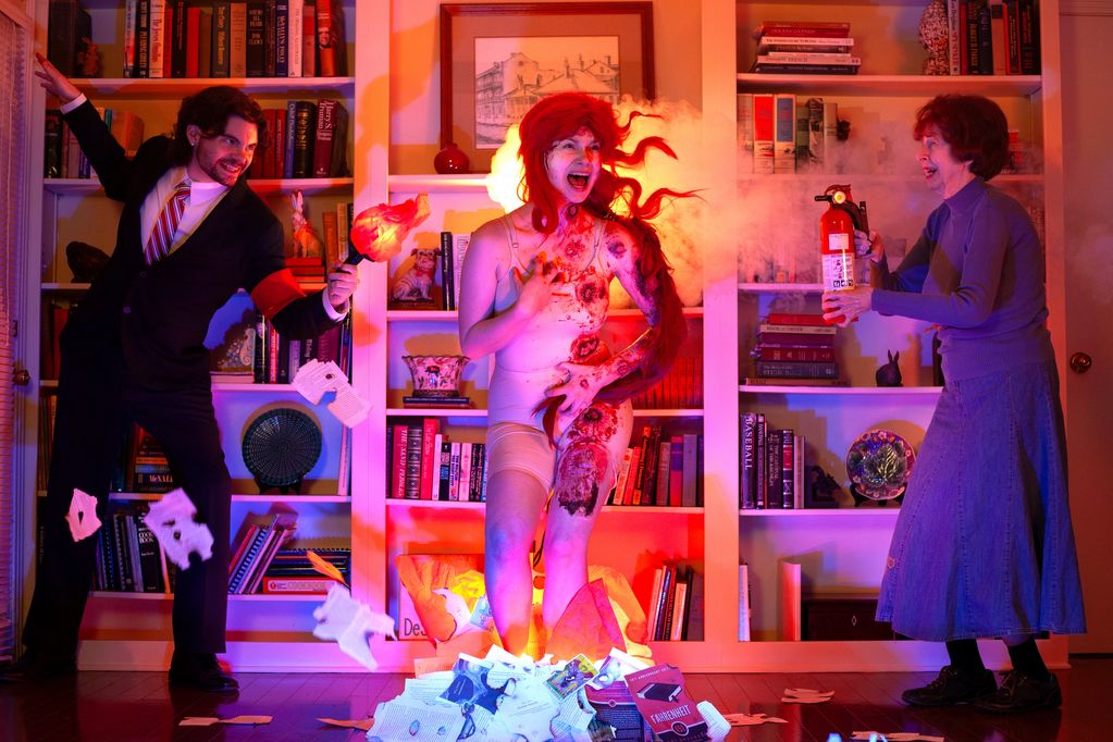 A chaotic scene with a woman on fire and people reacting.