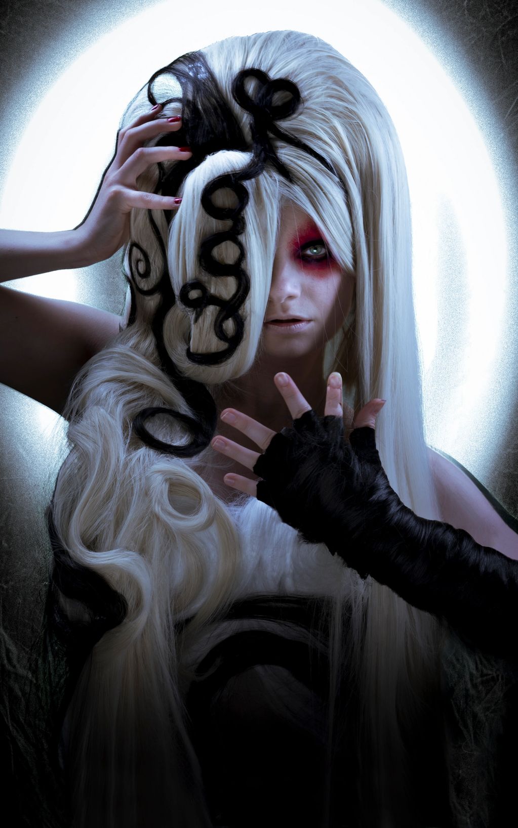 Person with elaborate black and white hair and dramatic makeup.