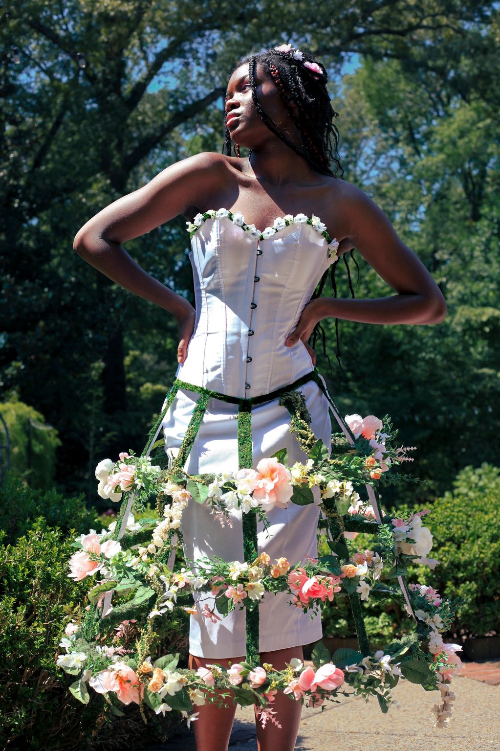 Woman wearing a floral and corset dress in a garden.