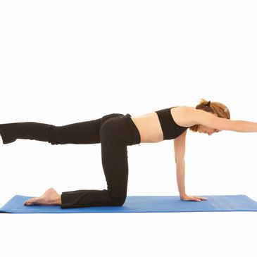 Woman doing yoga stretch on mat.