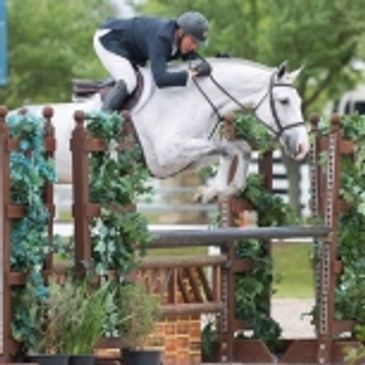 Bob Brawley jumping a fence on horseback