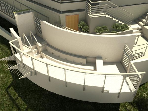 Modern curved balcony with metal railings and outdoor seating area.