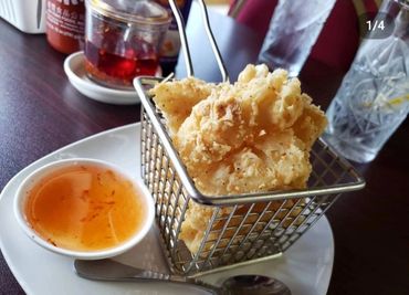 Crispy fried snack served with a side of dipping sauce on a white plate.