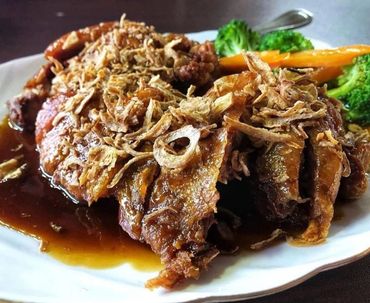 Crispy fried meat topped with fried shallots and served with broccoli and carrots.