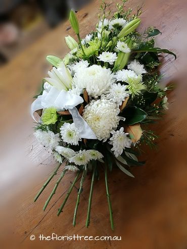 Mixed white and green flowers in a funeral sheaf created by a qualified florist