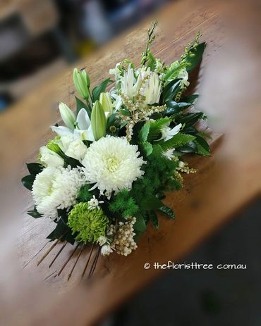 Mixed white and green flowers in a funeral sheaf created by a qualified florist