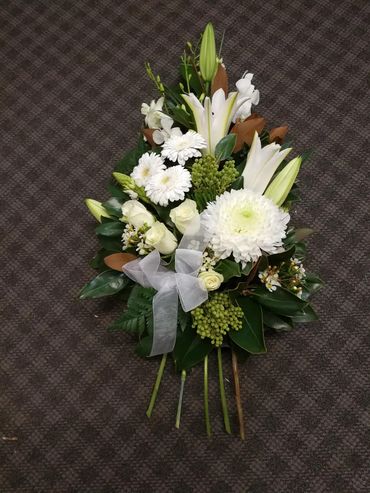 Mixed white and green flowers in a funeral sheaf created by a qualified florist