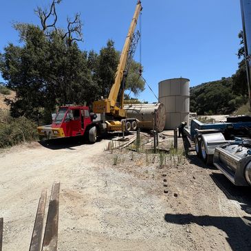 Crane installing  water tank onto private property