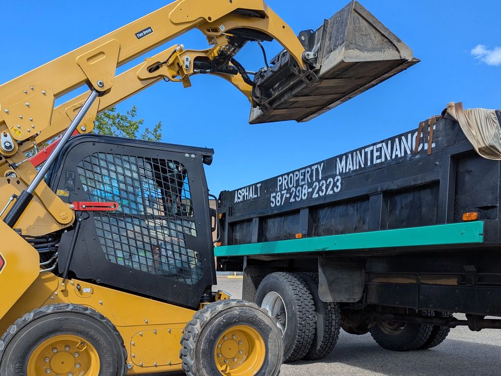 CAT skid steer: expert snow removal clearing, scraping for GP, AB. Commercial, residential, APM.