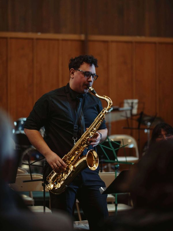Man playing saxophone indoors.